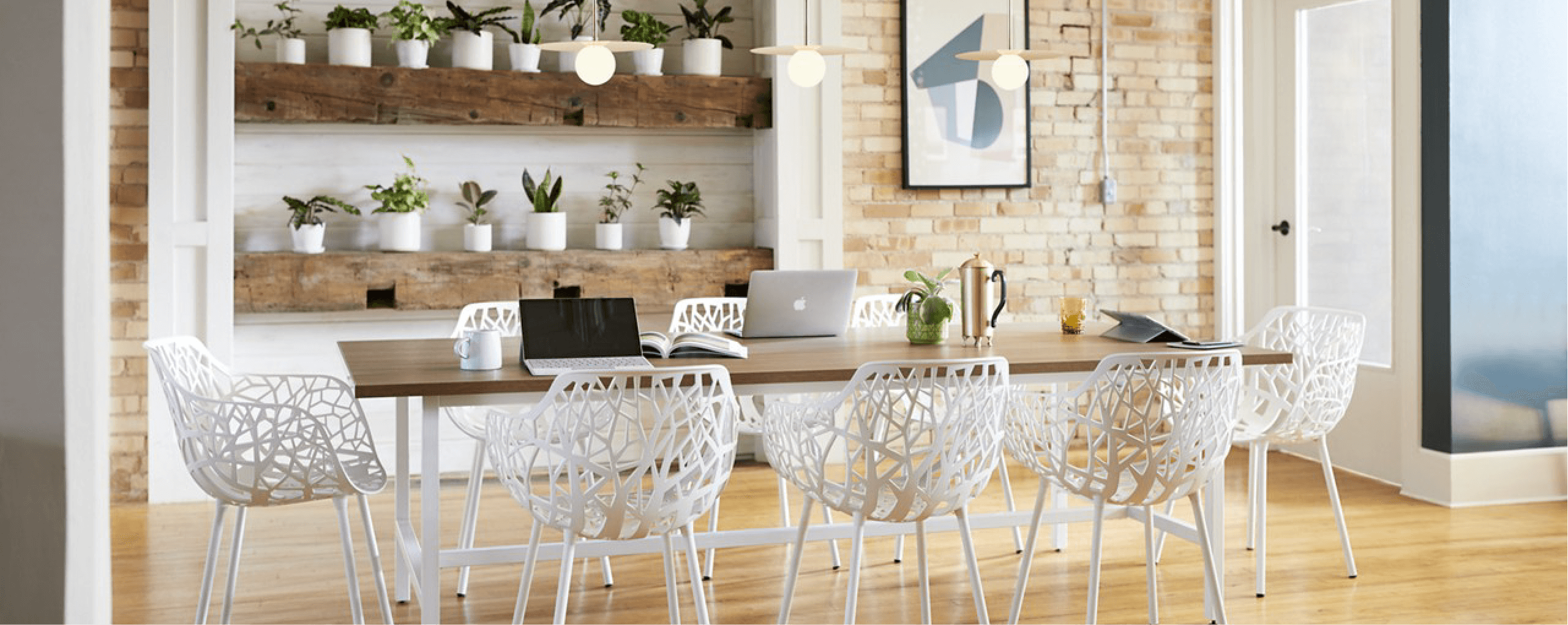 bright conference table with plants and brick wall