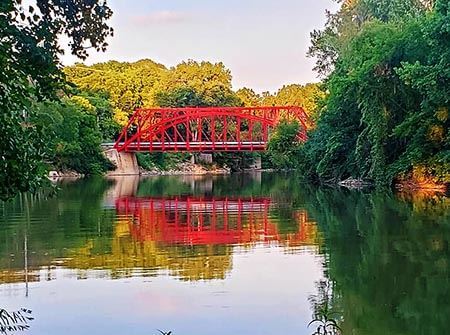 a red bridge over a shining lake